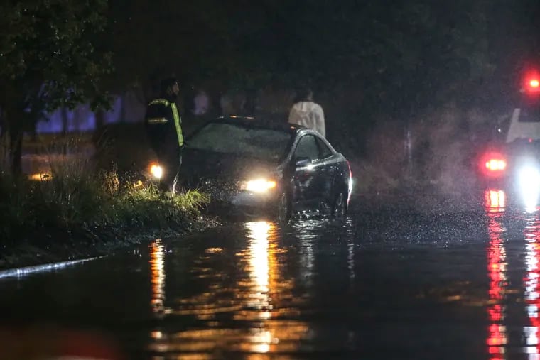 Cars are stranded in several feet of water along Columbus Boulevard just south of the BenFranklin Bridge at 9p.m. Friday as the Delaware River crests.