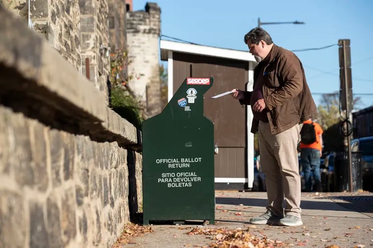 A voter drops off his mail ballot at the drop box at Eastern State Penitentiary in the Fairmount section of Philadelphia on Monday.