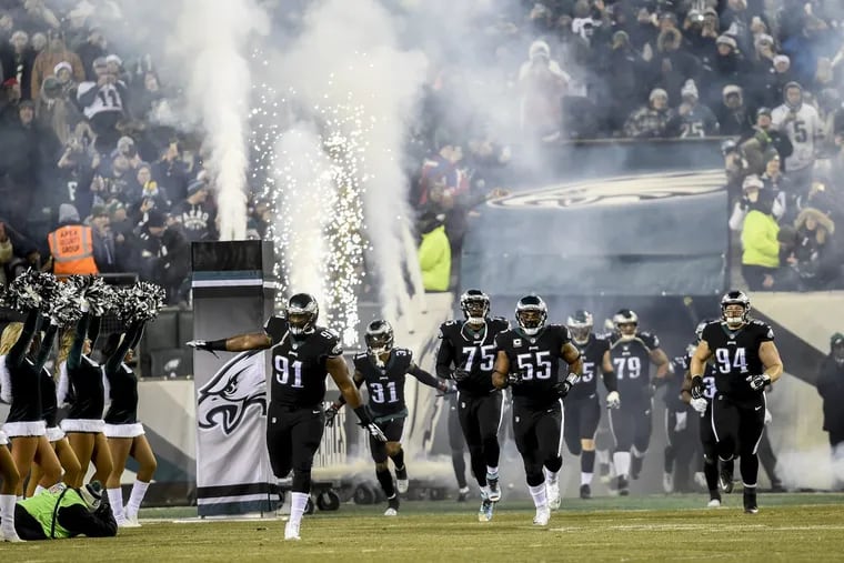 Eagles All-Pro defensive tackle Fletcher Cox (#91) leads his teammates, including (from left) Jalen Mills, Vinny Curry, Brandon Graham and Beau Allen, out onto the field for the game against the Oakland Raiders at Lincoln Financial Field in a Monday Night Football game Christmas night 2017. Eagles won 19-10. CLEM MURRAY / Staff Photographer