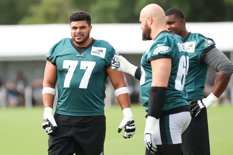 Eagles tackle Andre Dillard (77) speaks with Lane Johnson (65) on the first day of training camp open to the public and media at the NovaCare Complex in South Philadelphia on Wednesday, July 27, 2022