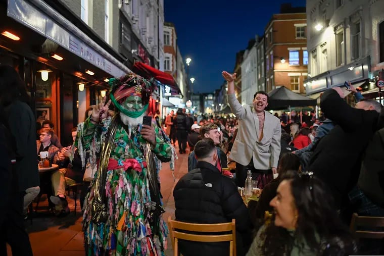 People sit at setup tables outside pubs in Soho, in London, on the day some of England's third coronavirus lockdown restrictions were eased by the British government on Monday. Open Table reservations are one way to track economic activity.
