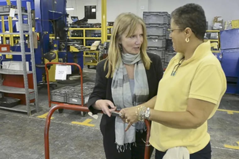 Tottser president Linda Macht (left) talks with quality manager Leslie Cousin. Macht owned a clothing store before joining her father in running Tottster in 1988. (Ron Tarver, Inquirer)