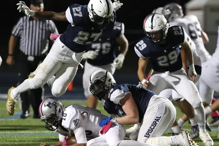 Malcolm Folk (27) of Episcopal Academy flies over Lonnie White of Malvern Prep after he was sacked by Max Strid in October 2019.