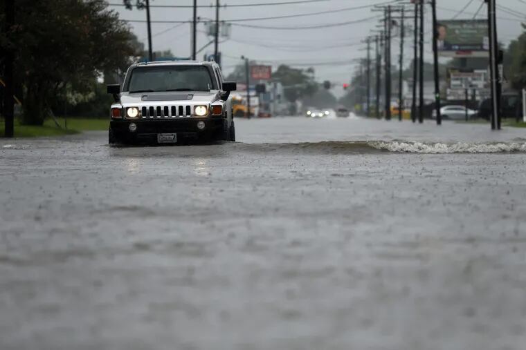 Cars drive through flooded streets in Lake Charles, La., as the city is receiving heavy rains from Tropical Storm Harvey. More storms are brewing, hurricane center says.