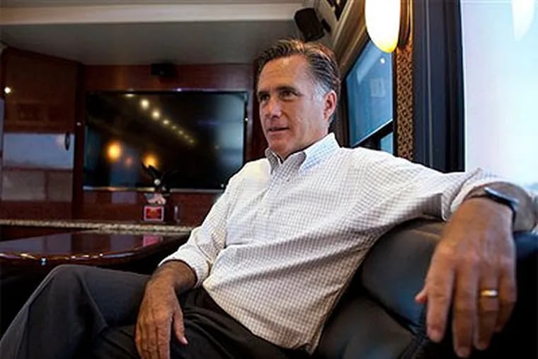 In this June 8, 2012 file photo, Republican presidential candidate, former Massachusetts Gov. Mitt Romney talks with his staff while riding on his bus after a campaign stop in Council Bluffs, Iowa.