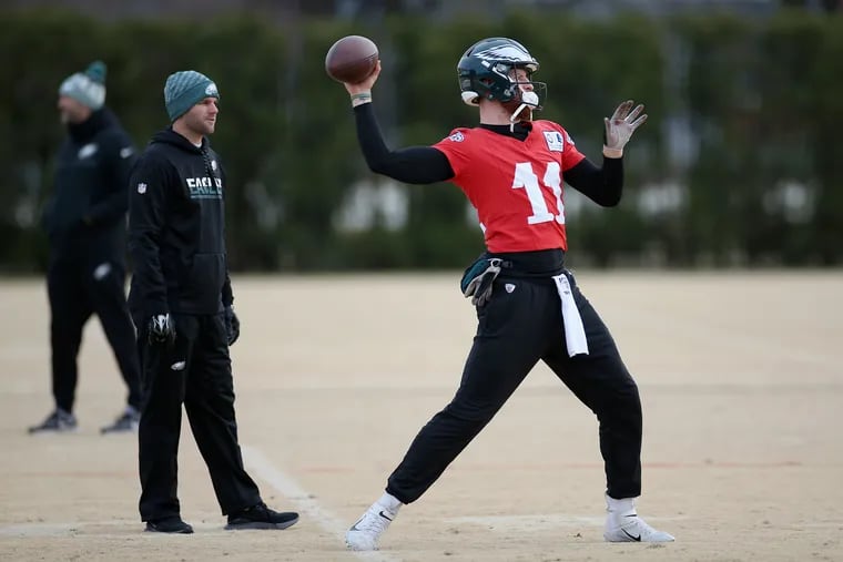 Eagles quarterbacks coach Press Taylor (left) watches quarterback Carson Wentz warm up during practice in 2019.
