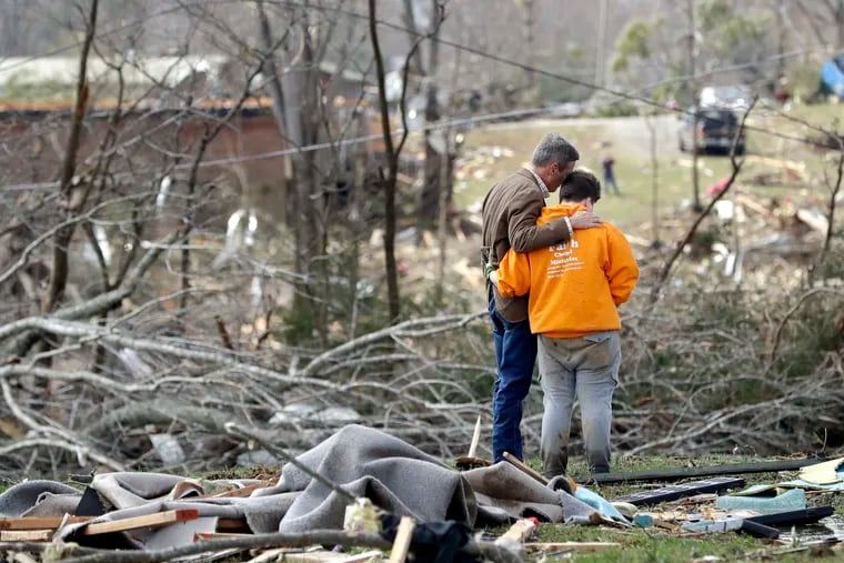 Tennessee Gov. Bill Lee, left, prays with Kayla Cowen, right, as Cowen looks through rubble in hopes of finding a neighbor Tuesday, March 3, 2020, near Cookeville, Tenn. Lee was touring damaged areas and met Cowen as she was searching. Tornadoes ripped across Tennessee early Tuesday, shredding buildings and burying people in piles of rubble and wrecked basements.
