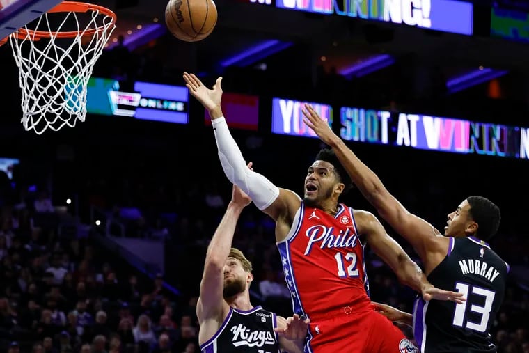 Sixers forward Tobias Harris gets fouled driving to the basket against Sacramento Kings forward Domantas Sabonis (left) and forward Keegan Murray in the first quarter on Friday, January 12, 2024 in Philadelphia.