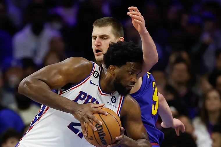 Joel Embiid of the Sixers drives to the basket against Denver Nuggets center Nikola Jokic on Jan. 28.