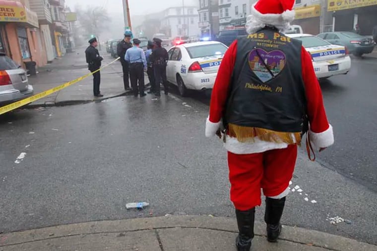 Philadelphia police investigate a shooting along Wayne Ave at Clapier in the Germantown section of the city on Monday morning December 10, 2012. Shown in foreground is Pat Redmond, aka Mrs. Pat, Heart of Philly community liaison at the crime scene.  ( ALEJANDRO A. ALVAREZ / STAFF PHOTOGRAPHER )