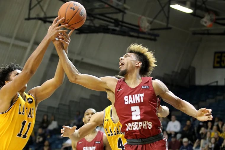 Ed Croswell, left, of La Salle and Charlie Brown of St. Joseph’s go after a rebound in the 1st half on Feb 5, 2019.