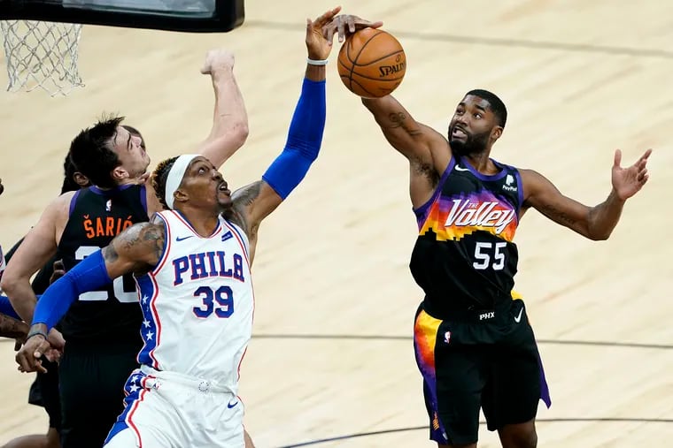 Phoenix Suns guard E'Twaun Moore (55) pulls down a rebound over 76ers center Dwight Howard (39) during the first half of an NBA basketball game, Saturday,