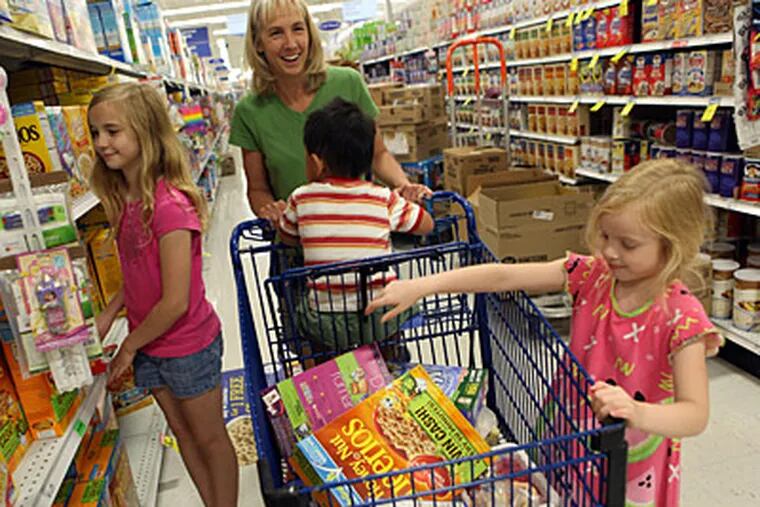 Tamara Waldschmidt, with son Nathan, 3, in her cart, gives daughters Kimberly, 5, and Alexis, 10, a few cereals to pick from at a store in Bolingbrook, Ill. Waldschmidt uses the store’s nutritional scoring system to guide her buying. (David Pierini/Chicago Tribune/MCT)
