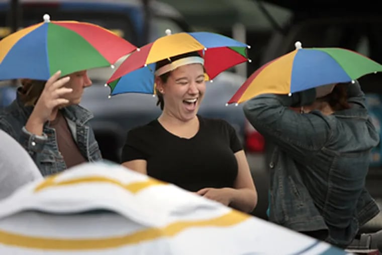 Joann Wentzell (left), Jeanne Staab and Christina Staab needed umbrella hats for protection from the elements prior to the Jimmy Buffet concert at the Tweeter Center tonight.  (Elizabeth Robertson / Staff Photographer)