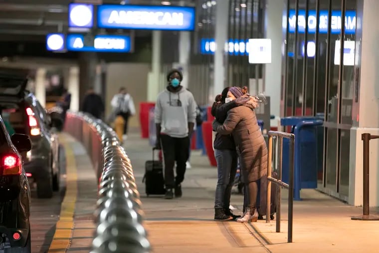 Travelers hug loved ones at the American Airlines departures terminal at Philadelphia International Airport on Sunday.