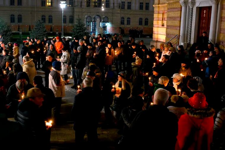 People carry candles in memory of 21-year-old David Dragicevic in Banja Luka, 240 kms northwest of Sarajevo, Bosnia, on Thursday, Jan. 3, 2019. Braving a police ban, dozens of Bosnians have lit candles to honor a 21-year-old student whose unresolved death has inspired months of protests alleging police cover-up in the case. The citizens of the Bosnian Serb city of Banja Luka gathered Thursday outside an Orthodox Christian church as police stood by. (AP Photo/Radivoje Pavicic)