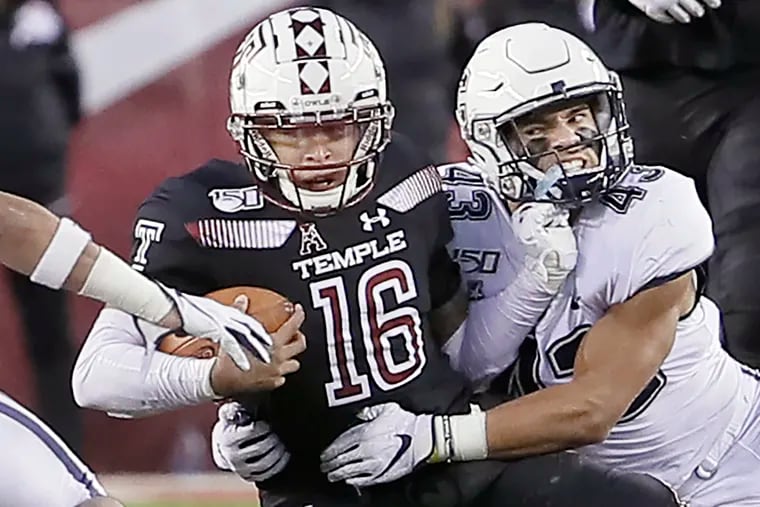 Temple quarterback Todd Centeio is pulled down by UConn’s Jackson Mitchell in the second quarter.
