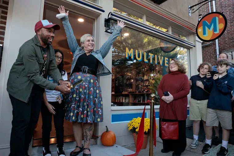 Gralin Hughes Jr. (from left), Sami Hughes, and Sara Zia Ebrahimi Hughes celebrate cutting the ribbon to their new bookstore, Multiverse, in the Chestnut Hill section of Philadelphia on Friday, Oct. 13, 2023.