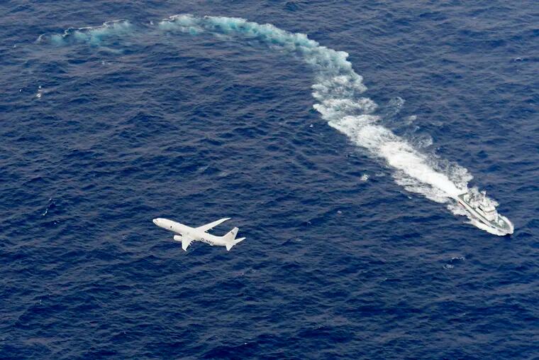 In this Dec. 6, 2018, file photo, Japan's Coast Guard ship, top, and U.S. military plane are seen at sea off Kochi, southwestern Japan, during a search and rescue operation for missing crew members of a U.S. Marine refueling plane and fighter jet. The U.S. Marine Corps have declared that five crewmembers dead after their aircraft crashed last week off Japan’s southern coast and that their search has ended. (Kyodo News via AP, File)