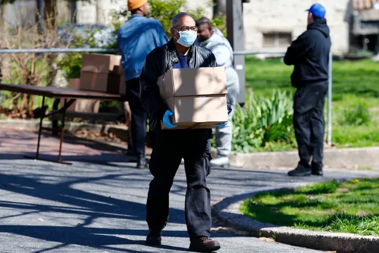 A resident carries free boxes of food at the Wharton Square Park in the Point Breeze section of Philadelphia on April 2, a food site supported by the City of Philadelphia, Share Food Program, and Philabundance. Share Food Program and Philabundance are two of the local nonprofit groups receiving grants from the PHL COVID-19 Fund, of which the City of Philadelphia is a key organizer.