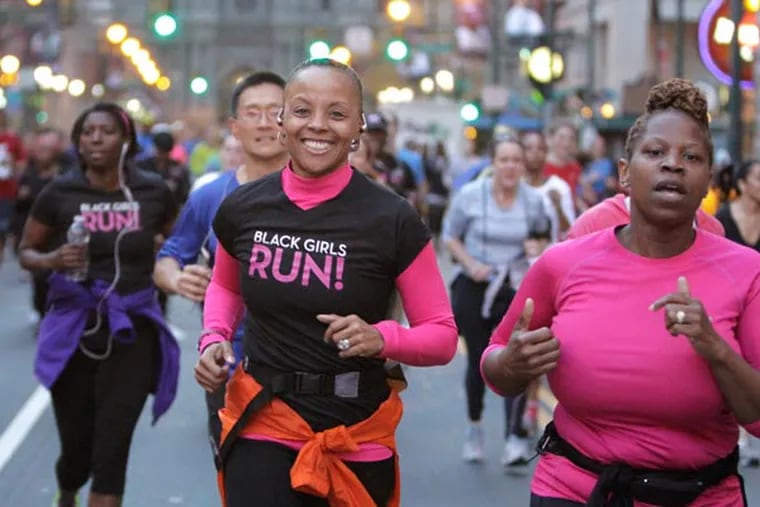 Beverly Brown (center) smiles as she runs with the running group "Black Girls Run" during a run from City Hall down Market St. to Independence Mall to show support for folks in Boston on April 18, 2013. (Elizabeth Robertson/Staff Photographer)