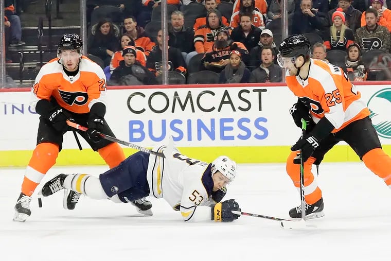 Flyers center Misha Vorobyev and left wing James van Riemsdyk pursue the puck against fallen Sabres left wing Jeff Skinner during the first period.