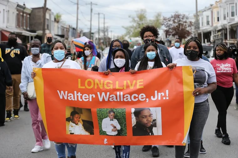 Lakitah Wallace (left) and Wynetta Wallace (right), both sisters of Walter Wallace, carry a banner in his memory as they march down Spruce Street in Philadelphia, Pa. on April 25, 2021. The event marks the six-month anniversary of the police shooting of Walter Wallace.