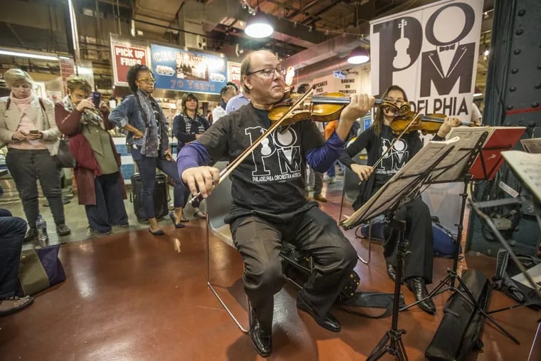 Philadelphia Orchestra violinists Paul Roby and Elina Kalendarova play in a string quartet at the Reading Terminal Market.