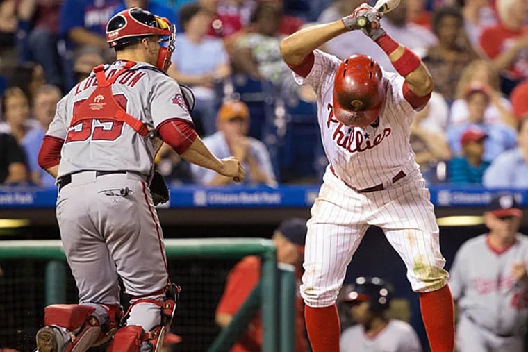 Philadelphia Phillies third baseman Andres Blanco (4) slams his bat to the ground in front of Washington Nationals catcher Jose Lobaton (59) after striking out to end the fifth inning at Citizens Bank Park.