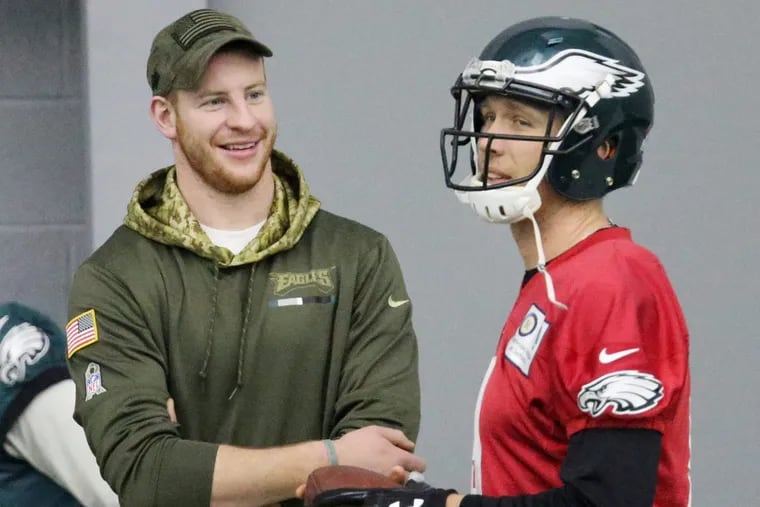 Injured quarterback Carson Wentz, left, talks with current starter Nick Foles during Eagles practice at the NovaCare Complex in South Philadelphia on Saturday, Jan. 27, 2018. TIM TAI / Staff Photographer