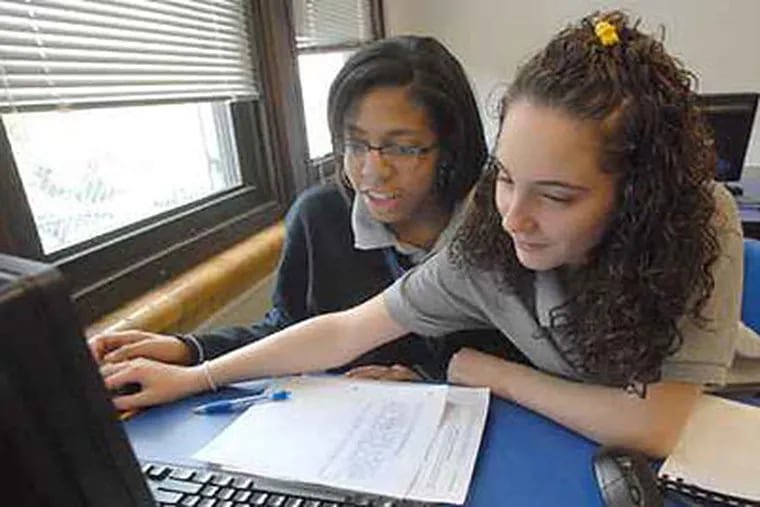 Students Savannah Kennedy, 15, left; and Brittany Brown, 16, use the computer in job readiness class last month at Mastery Charter School in Philadelphia. Three schools - Harrity, Mann and Smedley - will be matched with Mastery Charter, the school district announced today. (April Saul / Staff Photographer)
