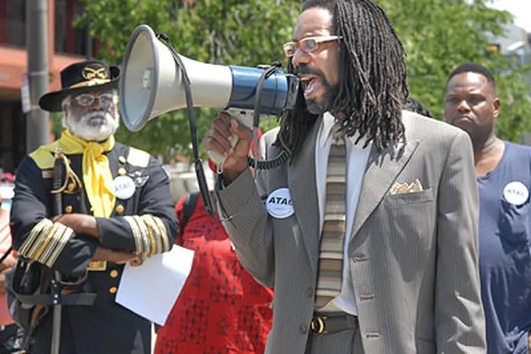 Michael Coard, head of Avenging the Ancestors Coalition; at left in soldier's garb is Dr. Daddese Ekulona of Philadelphia, were among the demonstrators to celebrate the escape of one of George Washington's slaves, Oney Judge, Friday at the site of the Presidents House at 6th and Market streets. (April Saul / Staff Photographer)