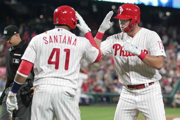 Rhys Hoskins (right) celebrates a home run against the Braves with teammate Carlos Santana.