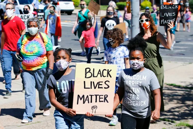 Children march holding a Black Lives Matter sign while entering Jefferson Square Park in South Philadelphia during a Children's March for Justice on Saturday.