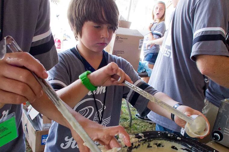 Ben Sparks, 11, of Beach Haven Gardens, fills sample cups with white chowder for a taste at the 25th annual Chowderfest on Long Beach Island Sunday, October 6, 2013. The cook-off offers a variety of clam chowders for people to vote on. DAVID M WARREN / Staff Photographer