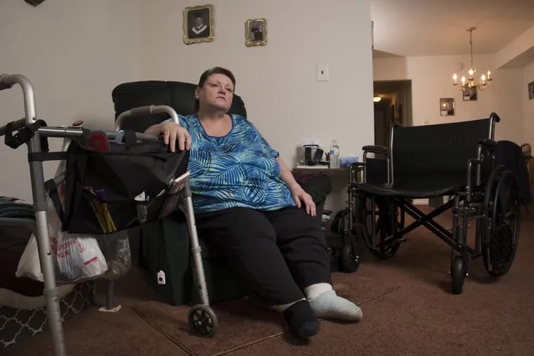 Carol Emanuele sits in her home in Philadelphia. She has been fighting a diabetes-related wound on the bottom of her left foot for 2½ years.