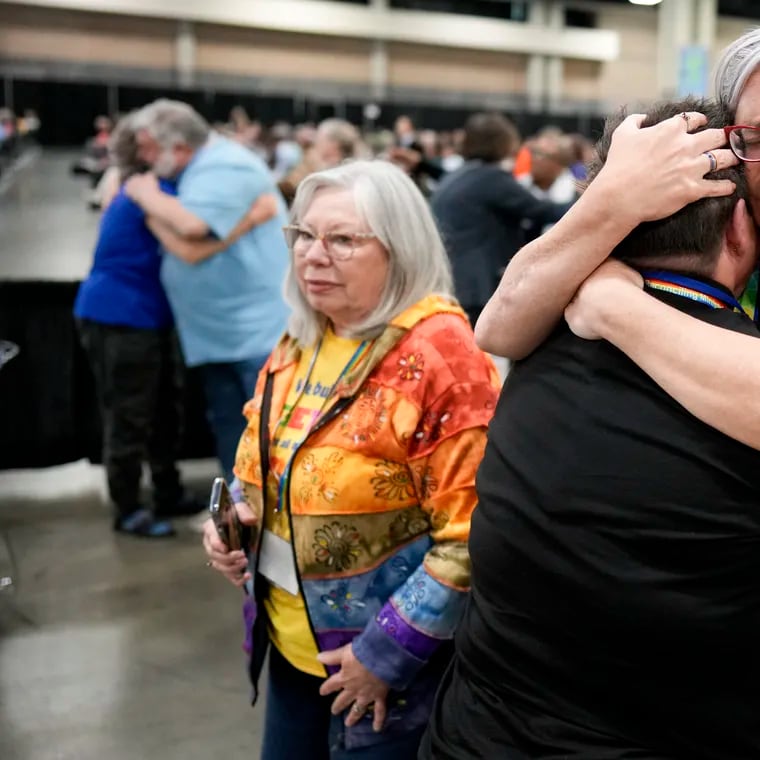 Angie Cox, left, and Joelle Henneman hug after an approval vote at the United Methodist Church General Conference in Charlotte, N.C. United Methodist delegates repealed their church’s longstanding ban on LGBTQ clergy with no debate on Wednesday, removing a rule forbidding “self-avowed practicing homosexuals” from being ordained or appointed as ministers.