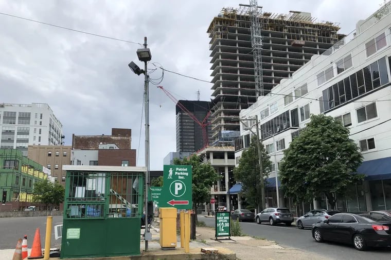 Entrance to parking lot at 139 N. 23rd St., where PMC Property Group is planning a new apartment building, with its under-construction River Walk project visible in background.