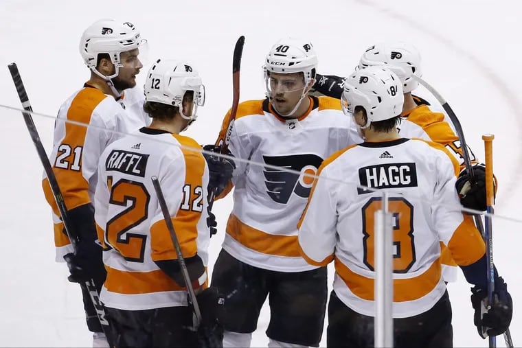 Flyers left wing Michael Raffl (12) celebrates his goal against the Arizona Coyotes with teammates Scott Laughton (21), Jordan Weal (40), Andrew MacDonald, second from right, and Robert Hagg (8) during the first period of the Flyers’ win on Saturday.