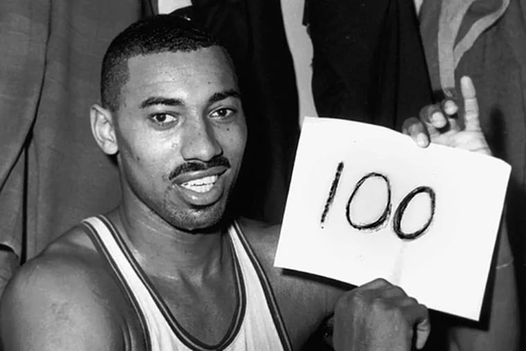 Wilt Chamberlain holds up a paper displaying his point total against the Knicks on March 2, 1962.
