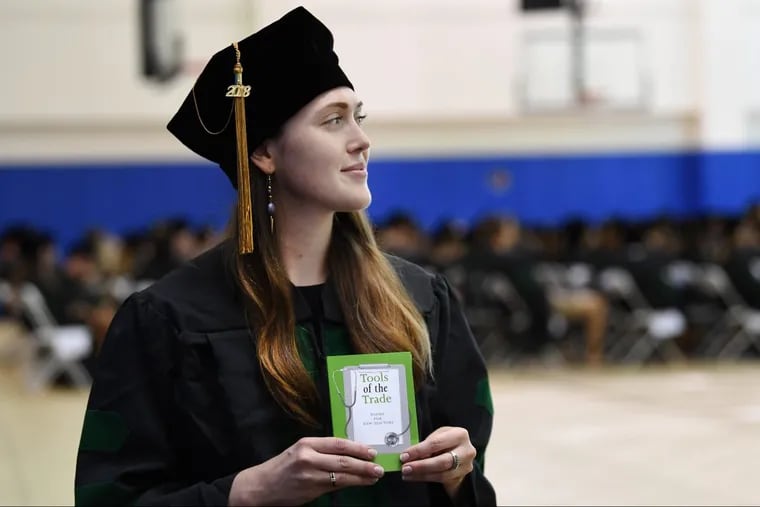 Claire Bogan, of Cherry Hill N.J., is thrilled with the book of poems she received from an alumnus of the Philadelphia College of Osteopathic Medicine. The college presented graduates-to-be with the books at a commencement practice on Wednesday. Many of the poems were written by doctors about the profession.