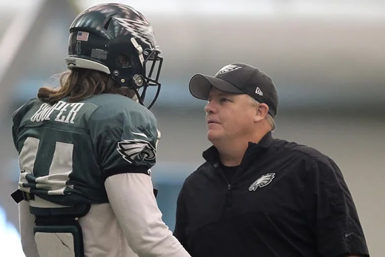Chip Kelly talks to wide receiver Riley Cooper. (David Maialetti/Staff Photographer)