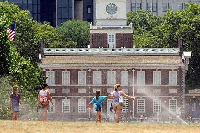 Cooling off in the midst of the mist of lawn sprinklers, visitors to Independence Mall get a bit of relief from a 2018 heat wave. Another one is about to get underway.