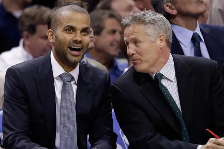 Tony Parker, left, of France, sits with assistant coach Brett Brown during the second half of an NBA basketball game, Wednesday, March 6, 2013, in San Antonio. Parked is out with a sprained ankle. (Eric Gay/AP file)