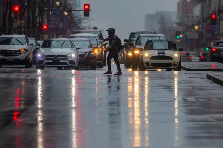 Car lights reflect off rain covered S. Broad St. at Chestnut Street on a rainy afternoon in Center City. The rains doused a remarkable dry spell.
