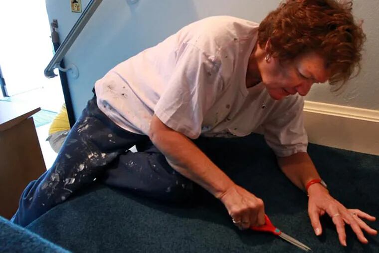 Karen Kain, who has been a member of Trinity since 1982, snips off small pieces of the new carpet that might have small bits of paint on it, in preparation for the grand opening of the refurbished sanctuary on Sunday. Volunteers put in hundreds of hours of elbow grease to refurbish the sanctuary at Cherry Hill's landmark Trinity Presbyterian Church, just in time for its 50th anniversary. 09/12/2014 ( MICHAEL BRYANT  / Staff Photographer )