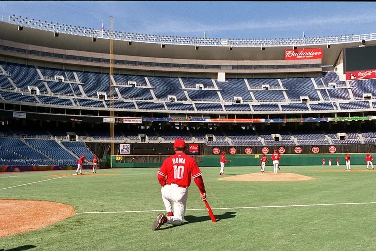 Then-Phillies manager Larry Bowa watches his team practice at Veterans Stadium before Opening Day in 2001. The Vet's infamous artificial turf was replaced five times during its 33-year history.