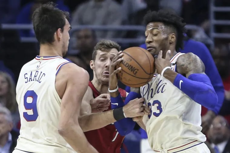 Sixers Dario Saric and Robert Covington keeping the ball from the Heat's Goran Dragic during Game 2 of this physical series.