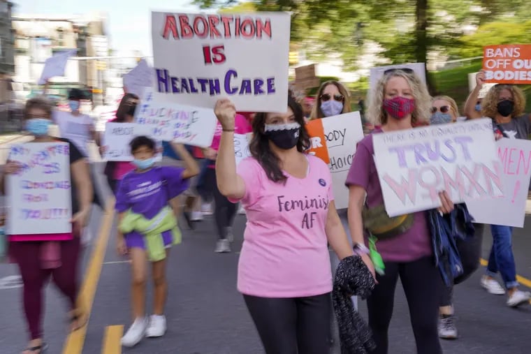 People march around the Pennsylvania State Capitol Building for the Bans Off Our Bodies rally in Harrisburg, Pennsylvania, October 2, 2021. The rally is part of demonstrations happening across the country defending women’s rights to seek abortions.