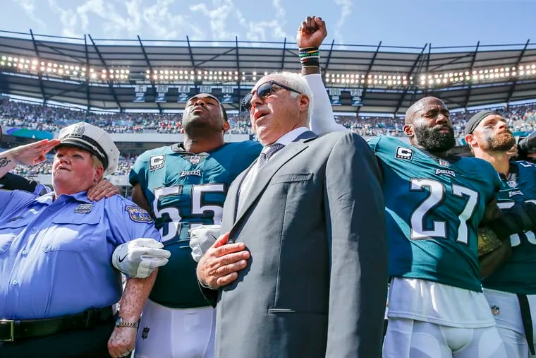 Eagles owner Jeffrey Lurie joins defensive end Brandon Graham (55) and safety Malcolm Jenkins during the national anthem. Jenkins raises his fist as a form of protest. 